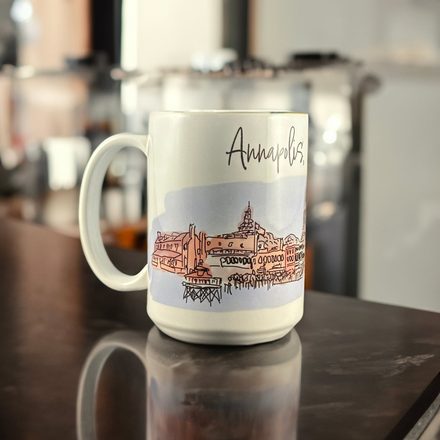 A white ceramic mug featuring an original hand-drawn illustration of downtown Annapolis, Maryland, by Andrew French. The design captures the charm of the Chesapeake and the city’s nautical heritage, blending everyday function with coastal artistry.