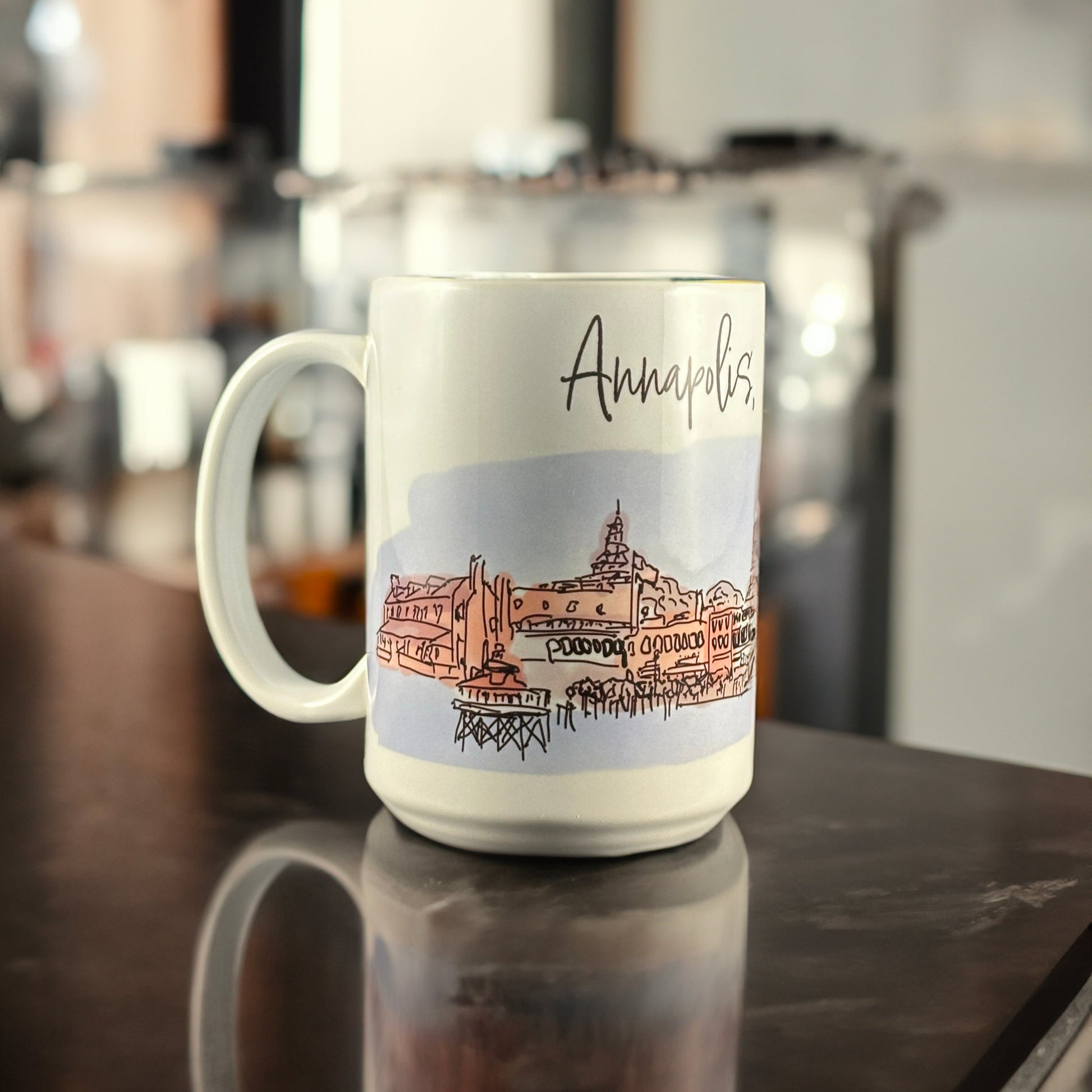 A white ceramic mug featuring an original hand-drawn illustration of downtown Annapolis, Maryland, by Andrew French. The design captures the charm of the Chesapeake and the city’s nautical heritage, blending everyday function with coastal artistry.