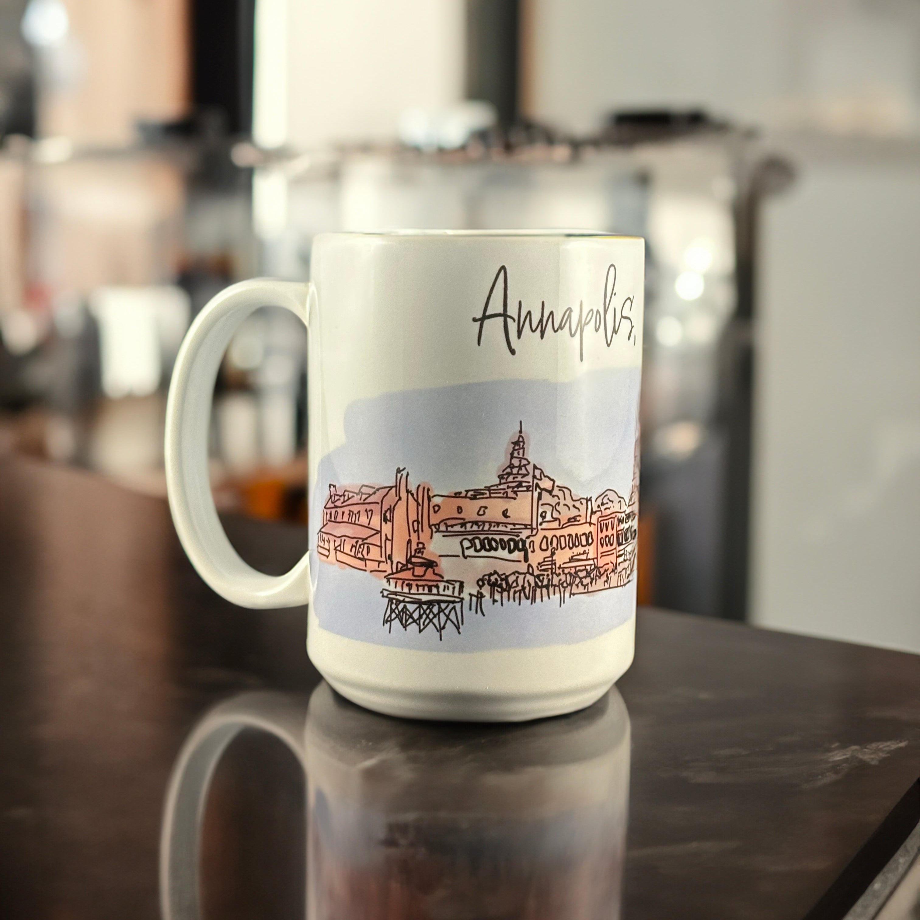 A white ceramic mug featuring an original hand-drawn illustration of downtown Annapolis, Maryland, by Andrew French. The design captures the charm of the Chesapeake and the city’s nautical heritage, blending everyday function with coastal artistry.