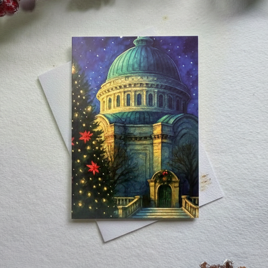 Decorative card with architectural design on a white surface with red berries and a pine cone.