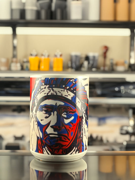 A bold ceramic mug featuring Andrew French’s “Chief” artwork. The design highlights a striking red, white, and blue portrait of a Native American chief, rendered in a modern, graphic-art style that blends cultural strength with contemporary design.