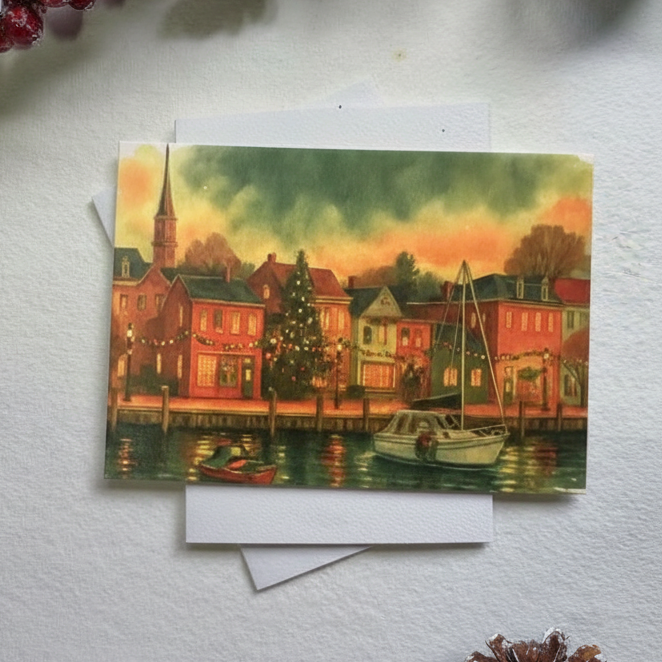 Vintage-style greeting card with a village scene on a white surface with decorative elements.