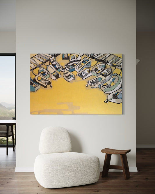 “Golden Hour on the Docks” by Andrew French displayed in a minimalist living space with a cream chair, wooden stool, and natural lighting, showcasing the artwork’s golden tones and coastal atmosphere.
