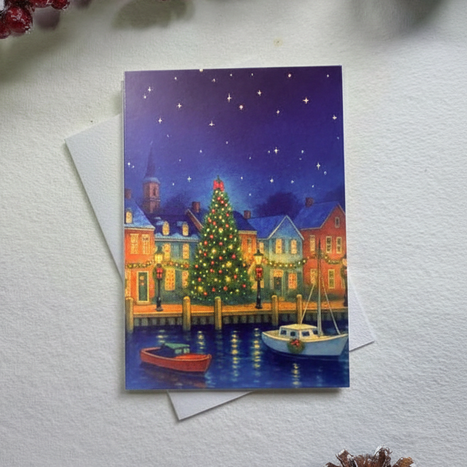 Christmas card with a festive scene of a town by water, surrounded by red berries and pine cones.