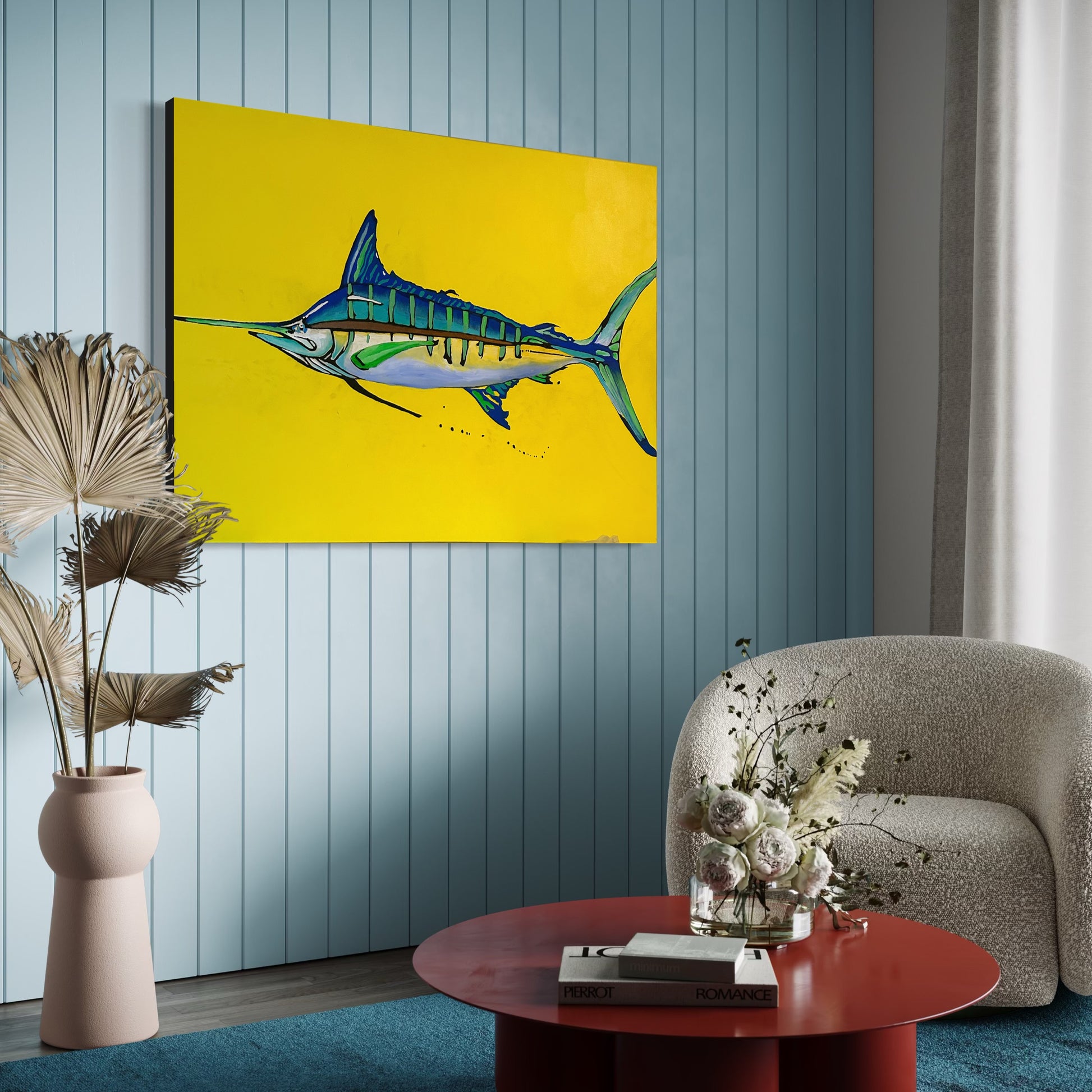 “Yellow Fin” by Andrew French displayed in a modern coastal room with soft blue walls and a cozy chair, showcasing the vibrant contrast between the marlin’s blue tones and the bold yellow background.